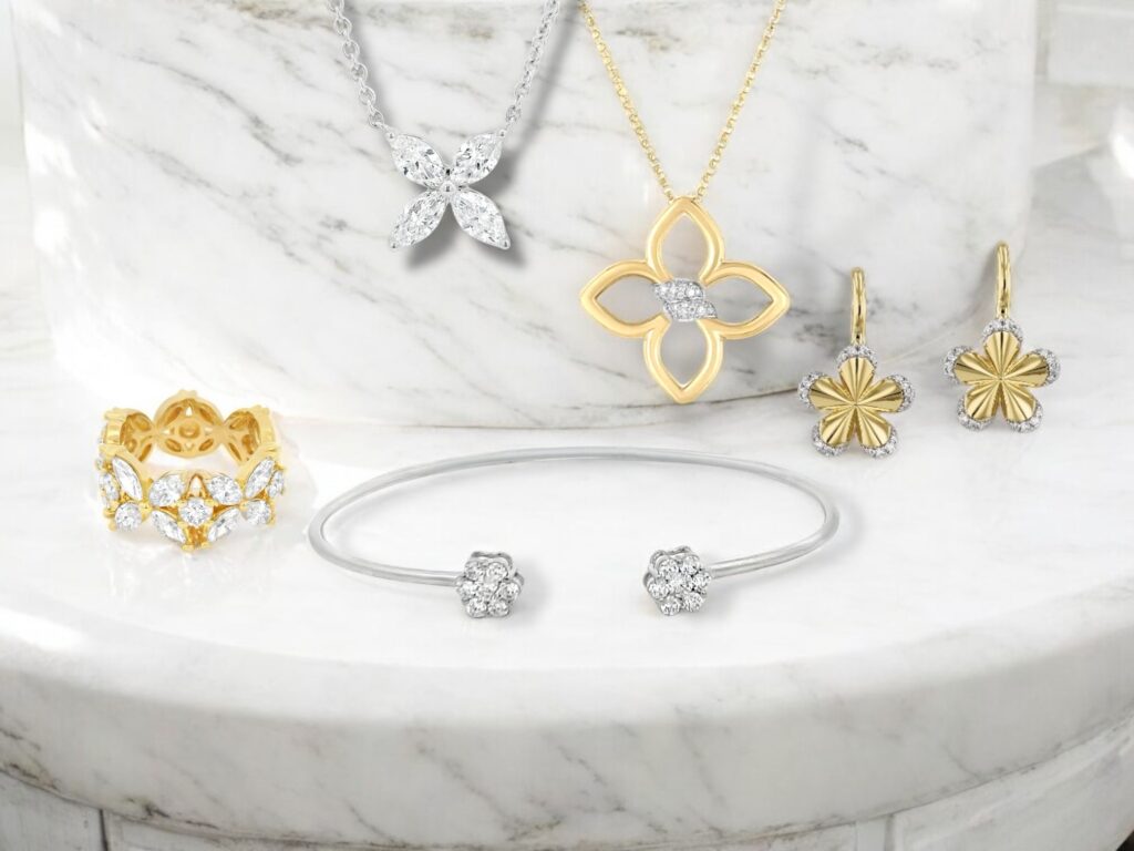 Elegant jewelry display on marble featuring gold and silver rings, bracelets, earrings, and necklaces.