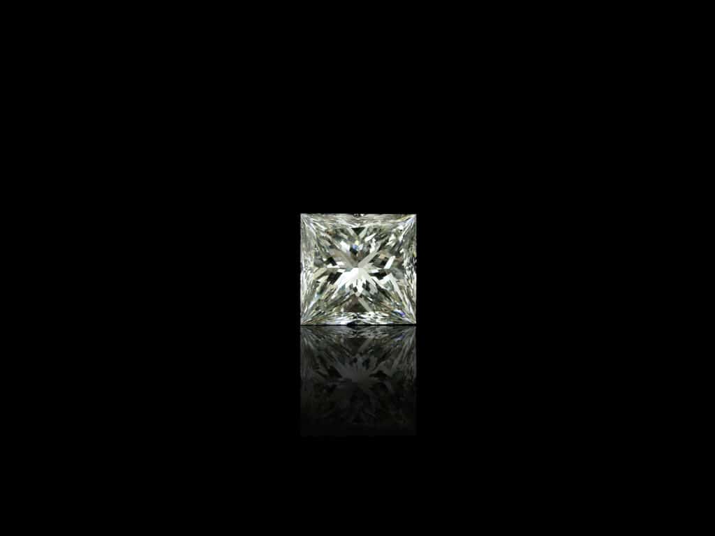 A DSLR photograph of a princess cut diamond on a black background