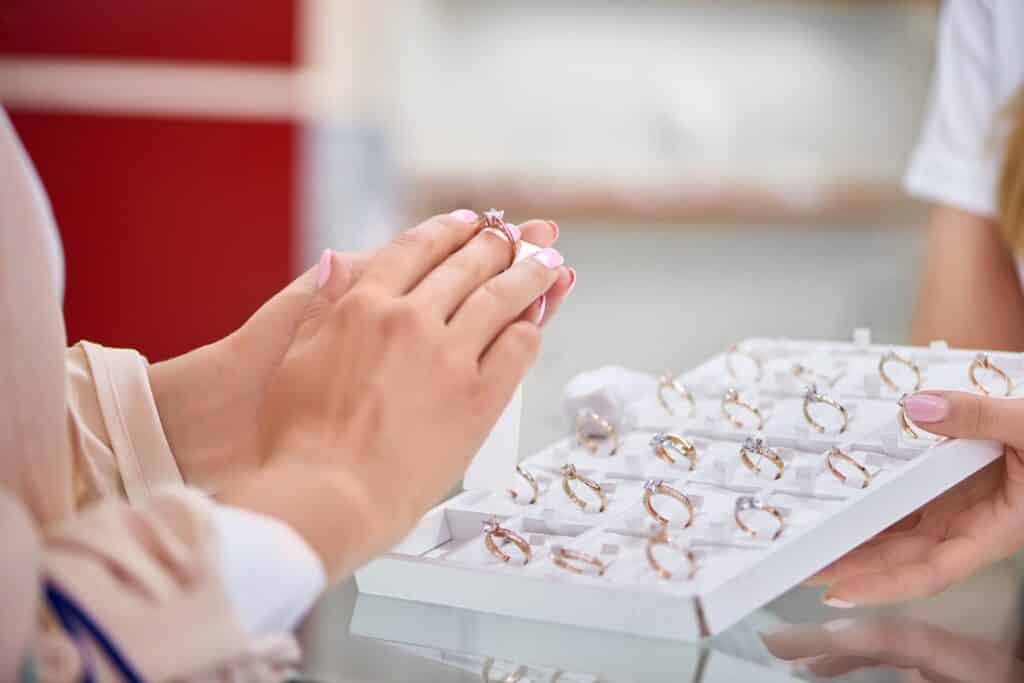 Cropped close up of a woman trying on an engagement ring at the jewelry store.