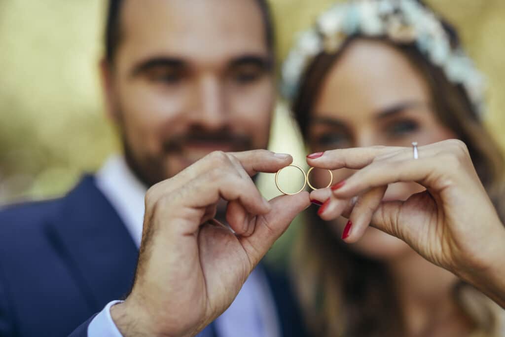 Happy bridal couple showing their wedding rings, close-up