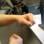 Women admiring new dainty permanent bracelet after her appointment at Brinker's Jewelrs.