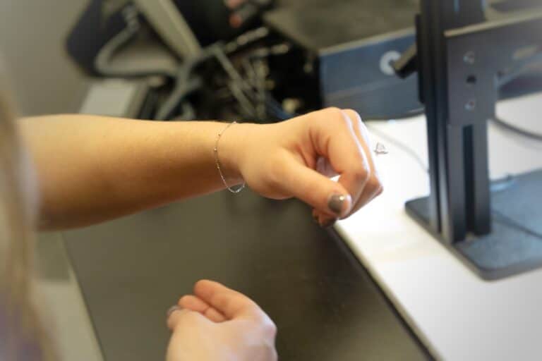 Women admiring new dainty permanent bracelet after her appointment at Brinker's Jewelrs.