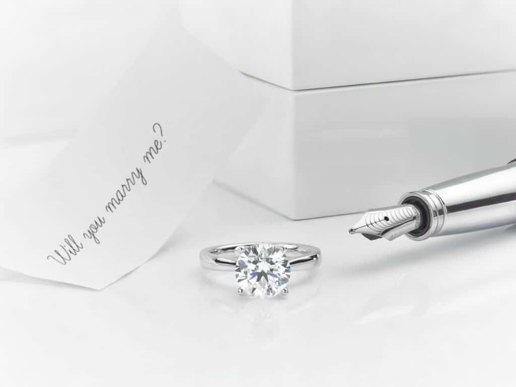 Round Diamond with white backgground and will you marry me paper