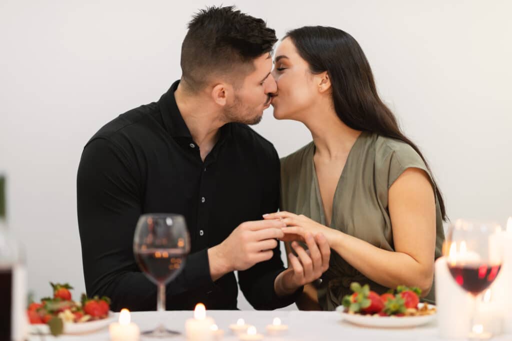 Loving couple kissing while have engagement celebration