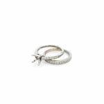 Elegant engagement and wedding rings with sparkling diamonds on a minimalist white background.