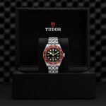 Luxurious Tudor watch in a sleek black box with striking red and black design.