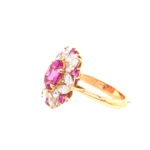 Elegant pink gemstone ring featuring floral white stone accents in a luxurious gold setting.