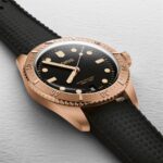Luxurious rose gold ORIS wristwatch with black dial, luminous markers, and rubber strap.