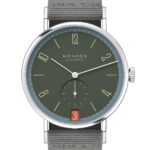NOMOS Glashütte watch, minimalist design, deep green dial, stainless steel, elegant fabric strap.