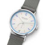 Elegant NOMOS Glashütte watch with cream dial, vibrant markers, and gray fabric strap.