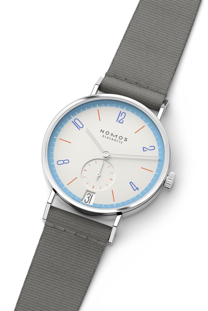 Elegant NOMOS Glashütte watch with cream dial, vibrant markers, and gray fabric strap.