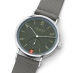 Elegant Nomos Glashütte watch with green dial, stainless steel case, and textile strap.