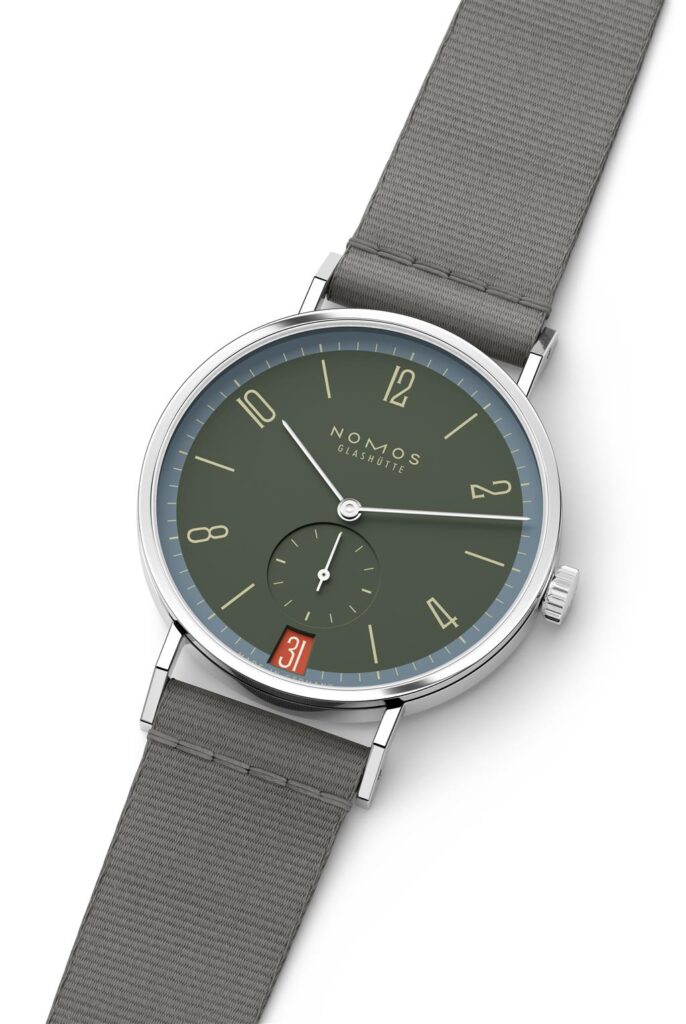 Elegant Nomos Glashütte watch with green dial, stainless steel case, and textile strap.