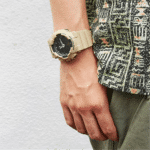 Casual watch on active wrist, vibrant abstract shirt against a simple background.