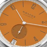 Vibrant NOMOS Glashütte watch with orange dial, minimalist design, and elegant details for modern style.
