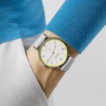 Stylish turquoise shirt and vibrant yellow watch create a chic, modern look.