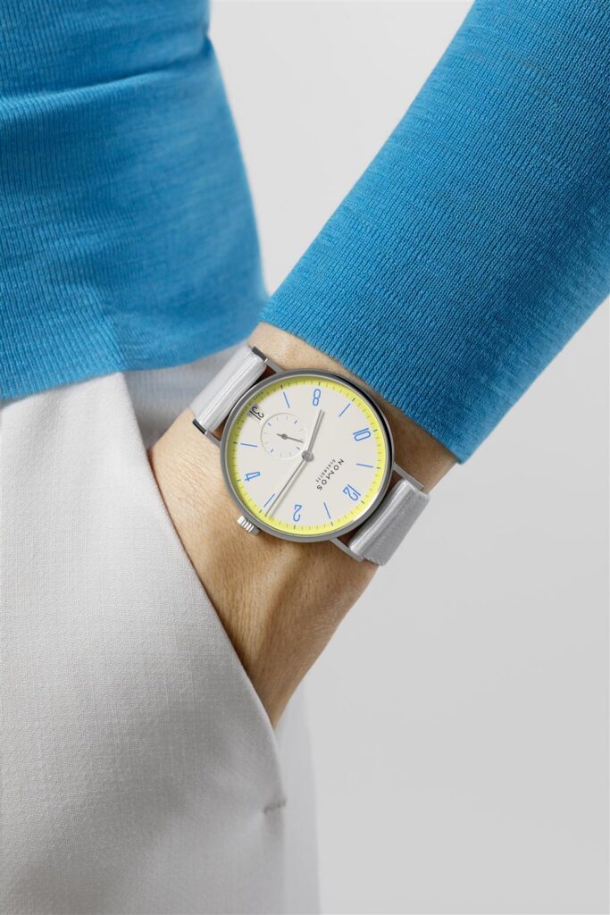 Stylish turquoise shirt and vibrant yellow watch create a chic, modern look.