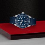 Elegant Tudor wristwatch with blue dial, stainless steel case, and leather strap on a sleek background.