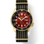Elegant Seiko watch featuring a gold case, vibrant red dial, and sporty black strap.