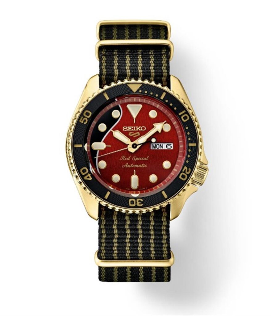 Elegant Seiko watch featuring a gold case, vibrant red dial, and sporty black strap.
