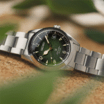 Elegant Seiko watch with green dial and metallic bracelet, showcased on a cork surface.