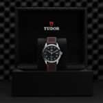 Elegant Tudor watch in green dial and leather strap, showcased in luxurious presentation box.