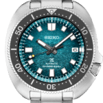Vibrant Seiko dive watch with teal dial, luminous hands, and stainless steel bracelet.
