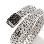 Elegant silver bracelet with black stone clasp, showcasing intricate woven design and modern style.