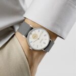 Modern minimalist watch on gray shirt, featuring a sleek design with blue markers.