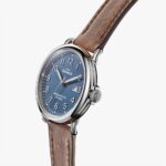 Stylish Shinola wristwatch features a blue dial, silver case, and leather strap for timeless elegance.