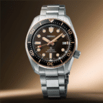 Seiko automatic divers watch with brown dial, rose gold bezel, and stainless steel bracelet.