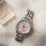 Elegant Seiko watch with pink face and sparkling details on plush fabric surface.