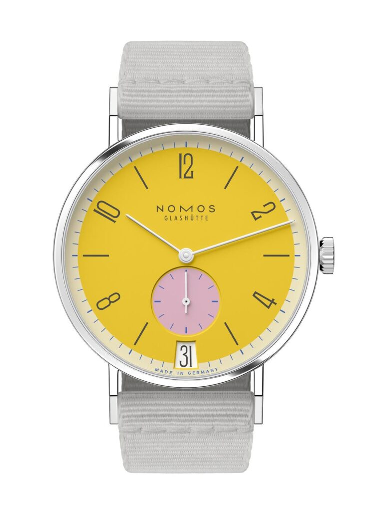 NOMOS Glashütte watch with vibrant yellow dial, pink sub-dial, and gray textile strap.