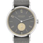 NOMOS Glashütte luxury watch features an oval design with a gray dial, yellow accents, and date function.