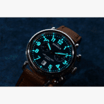 Stylish SHINOLA watch with black dial, blue luminescent accents, and brown leather strap.