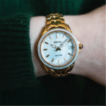 Elegant Seiko watch on a wrist with a dark green sweater, showcasing luxury and style.