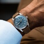 Elegant Oris wristwatch featuring a blue dial and brown leather strap on a stylish wrist.