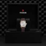 Tudor luxury watch displayed in elegant black box with rose gold and leather design.