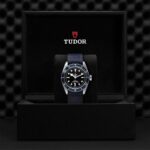 Sophisticated Tudor dive watch in luxury black box with blue strap and rotating bezel.