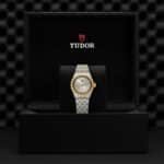 Luxurious Tudor watch in presentation box, featuring silver and gold accents, gray dial, and Roman numerals.