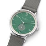 NOMOS Glashütte watch features a stunning green dial and stainless steel case with a textile strap.