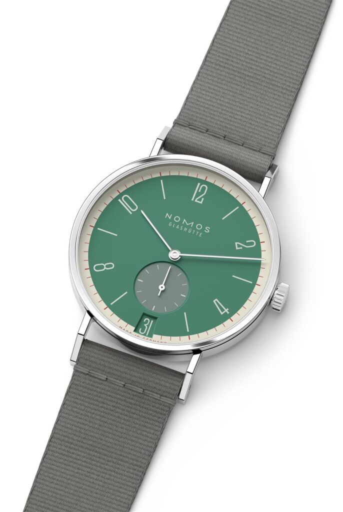 NOMOS Glashütte watch features a stunning green dial and stainless steel case with a textile strap.