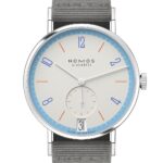 Elegant NOMOS Glashütte watch with minimalist design, pale cream face, and gray fabric strap.