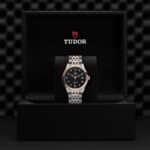 Elegant wristwatch in a luxurious box, featuring a black dial and rose gold accents.