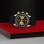 Stylish Tudor chronograph watch with black dial, yellow accents, and stainless steel case.