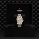 Luxurious Tudor watch in elegant presentation box, featuring a silver dial and gold accents.