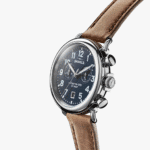 Elegant navy blue stainless steel watch with chronograph features and tan leather strap.