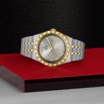 Luxury silver and gold watch with Roman numerals on a stylish black background.