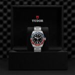 Elegant Tudor watch in luxury black presentation box with red and blue bezel.