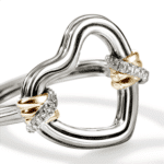 Elegant heart-shaped ring with intertwining silver and gold bands, adorned with sparkling gemstones.